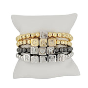 Love Lisa personalized large block letter bracelets displayed on pillow in gold silver and gunmetal stack