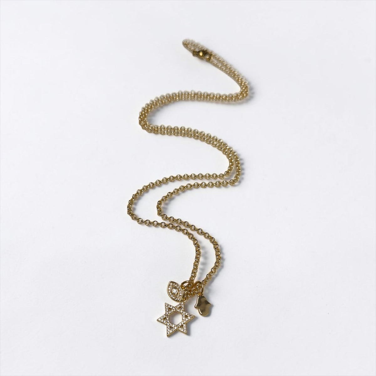 Love Lisa Rayna long Gold protection necklace shown with Star of David, crystal evil eye, and Hamsa charm cluster on an extended delicate chain