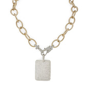 Gold chain necklace with a silver pendant on a white background
