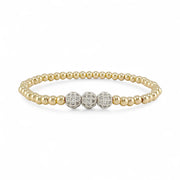 Gold beaded bracelet with three diamond-studded beads on a white background