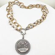 Necklace with pearl and gold chain and silver pendant on a white background