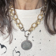 Necklace with pearl and gold chain and silver pendant on a model