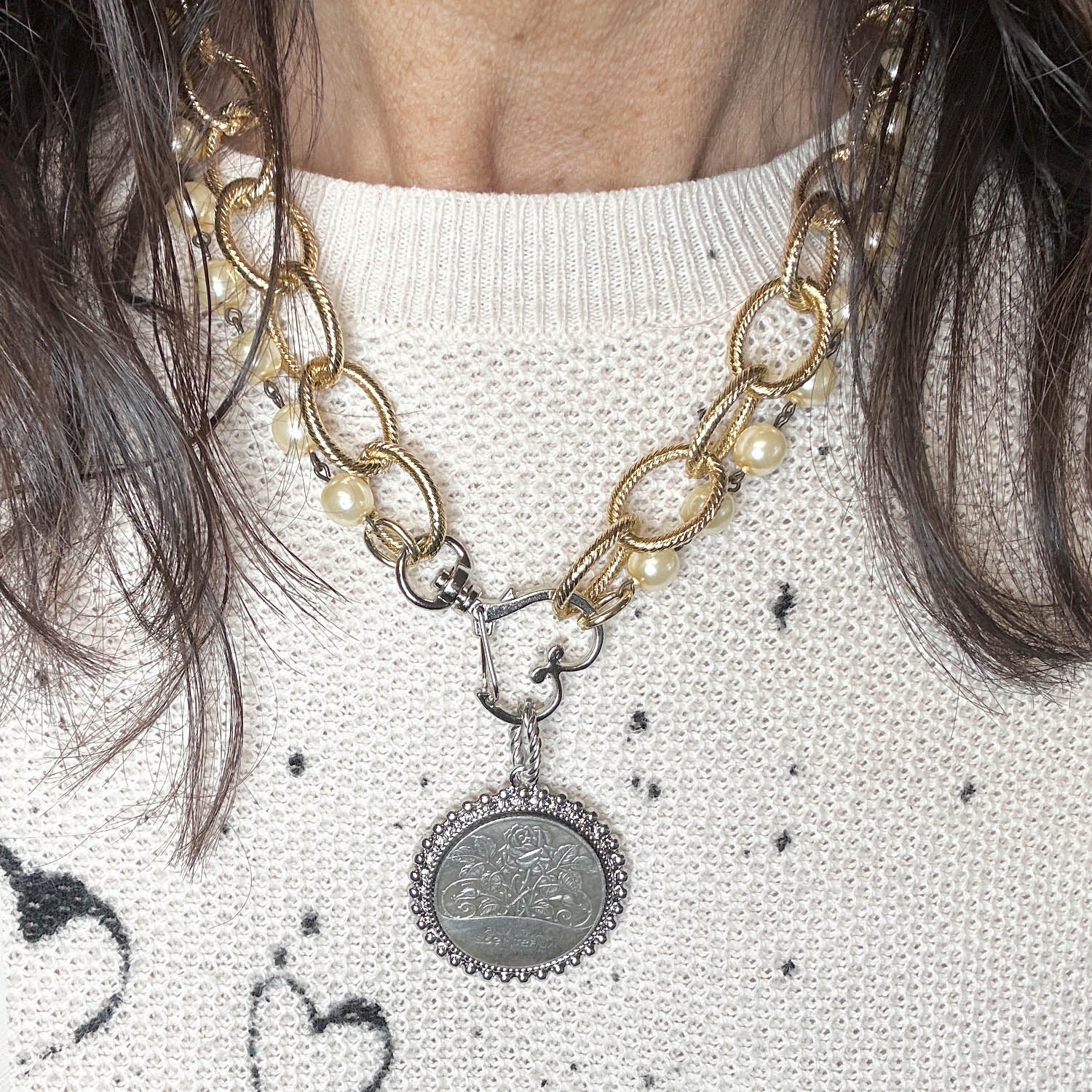 Necklace with pearl and gold chain and silver pendant on a model