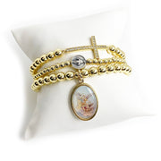 saint Michael colorful beaded bracelet gold stretch fit stack on pillow. saint Michael is honored as the protector and spiritual warrior who defends against evil and guides the faithful.
