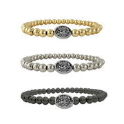 Three beaded bracelets with brass beads and central saint michael medal on a white background