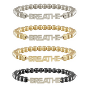 Set of four beaded bracelets with 'BREATHE' charm in different colors on a white background