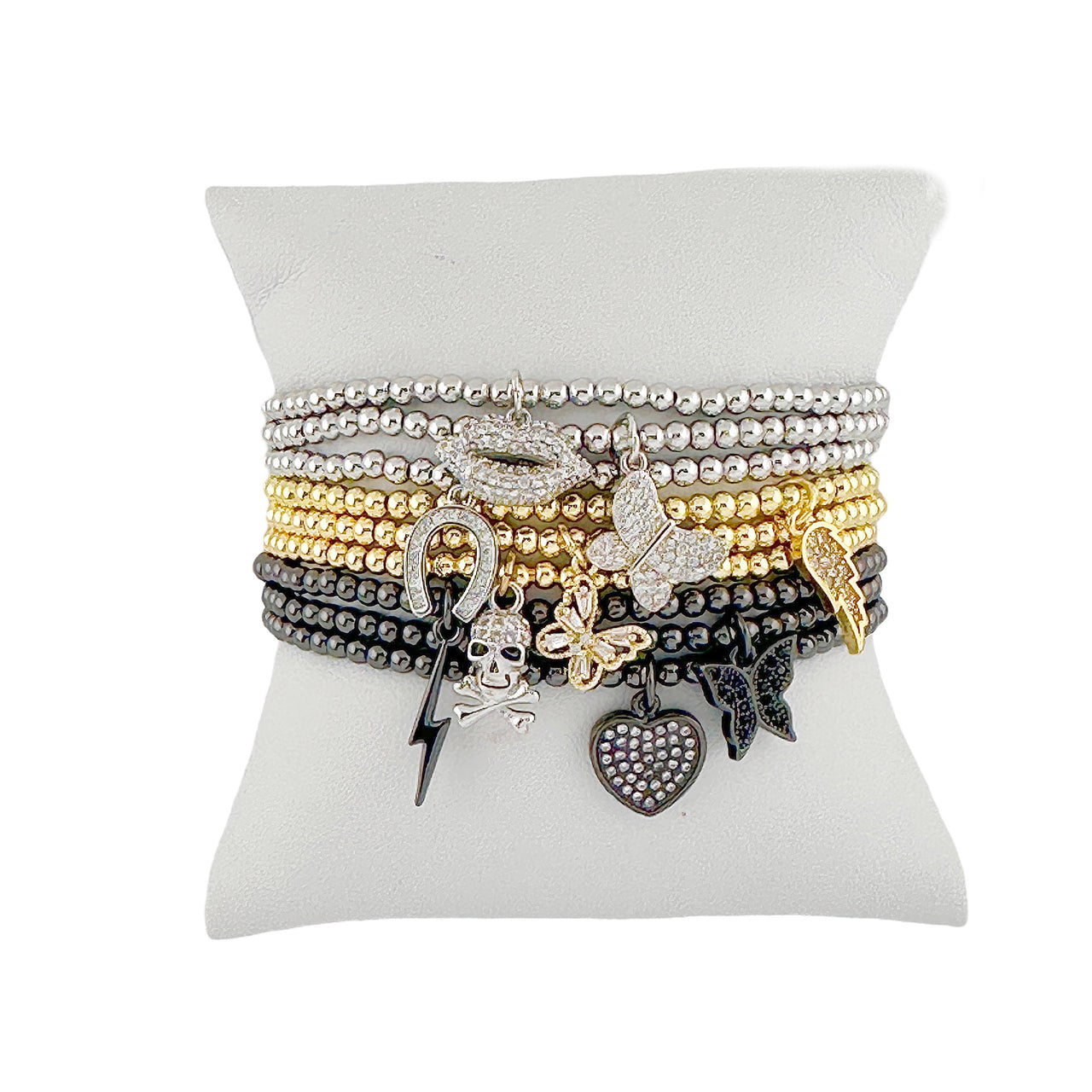 Set of bracelets with various charms on a white stand