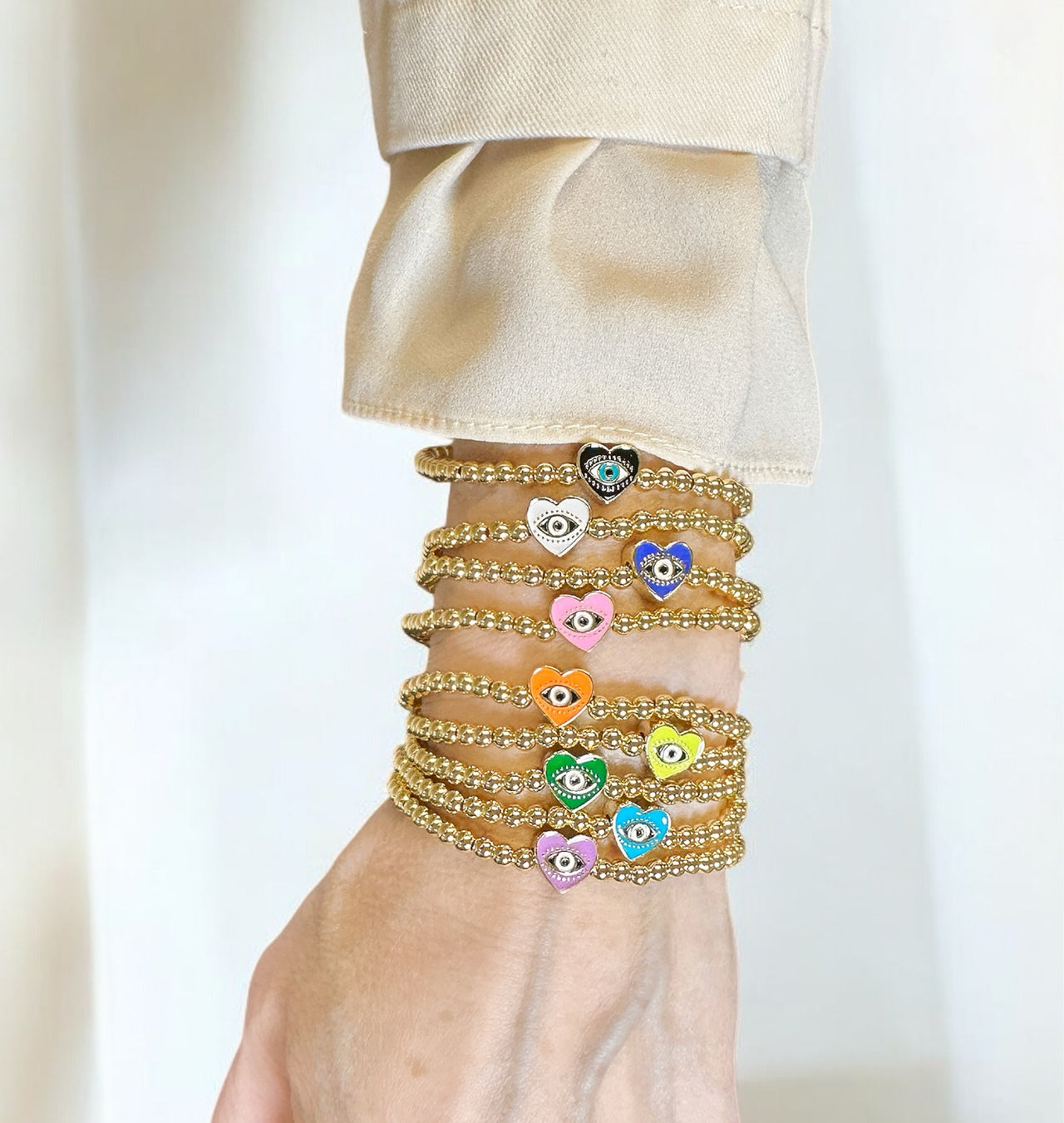 an arm stack of sandi enamel evil eye heart bracelets