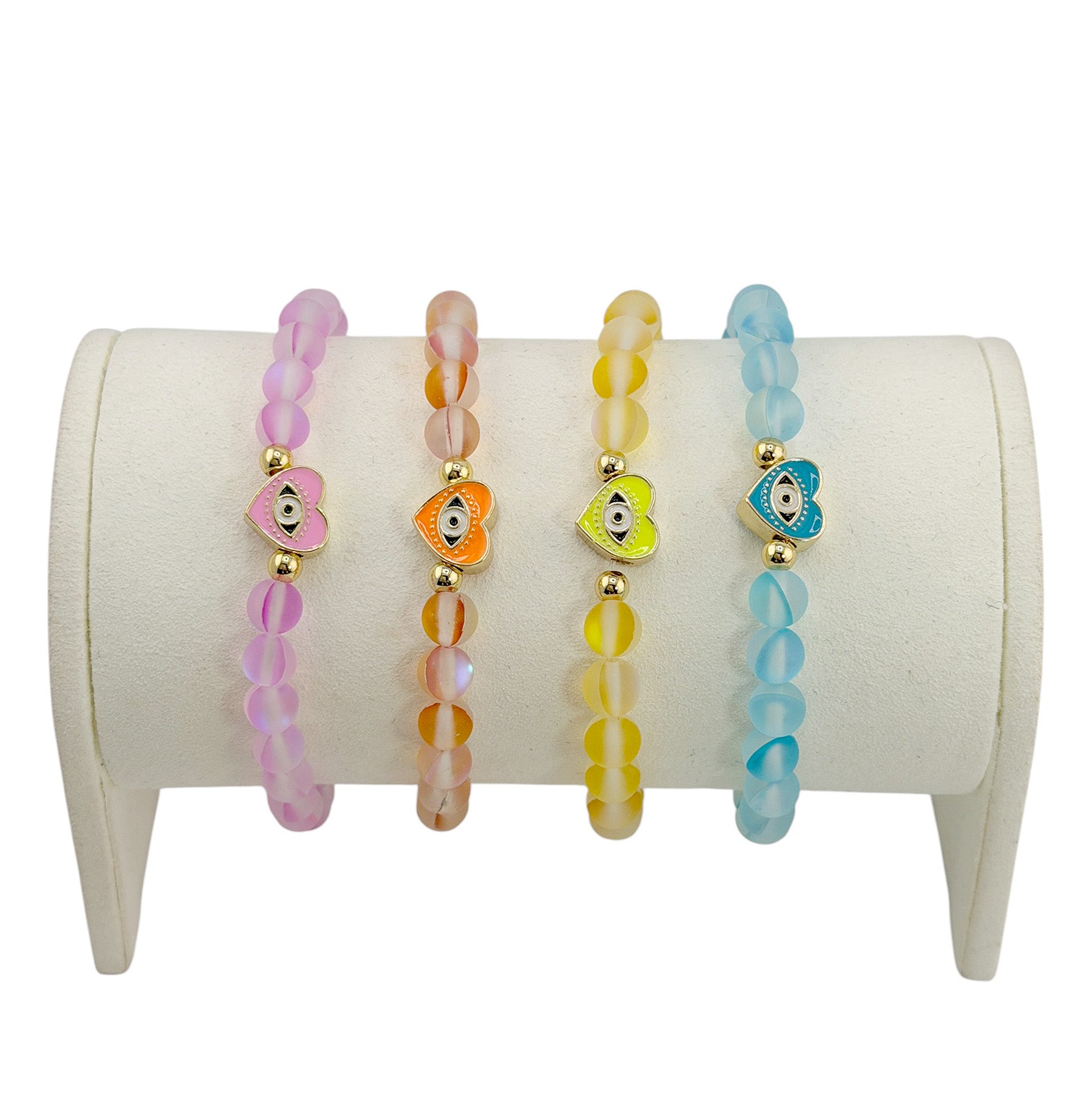 Sandi Heart of Protection mermaid evil eye bracelet collection in pink orange yellow and blue with gold heart charms displayed on bracelet stand
