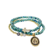 Turquoise beaded bracelet with gold and silver charms on a white background