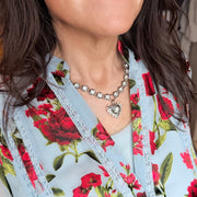 Love Lisa crystal heart statement necklace styled with layered jewelry and patterned fashion styling