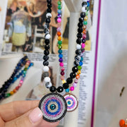 closeup of fire agate gemstone evil eye necklace pendant with crystals