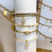 
Shalom Blessings Bracelet Stack in gold and champagne with faceted beads symbolic charms and elastic fit measuring 6.85 inches