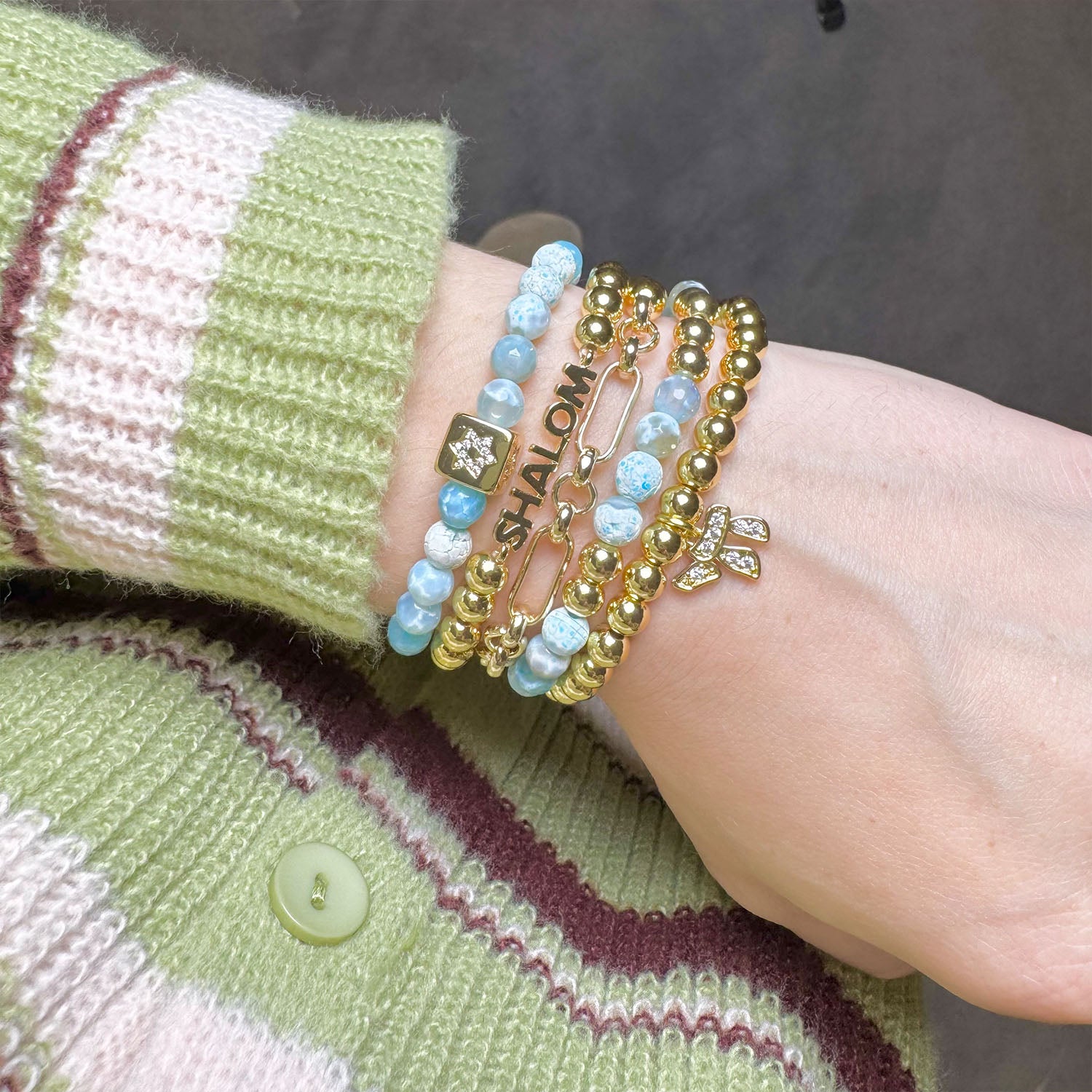 love lisa shalom bracelet stack worn on wrist with star of david shalom and chai charms