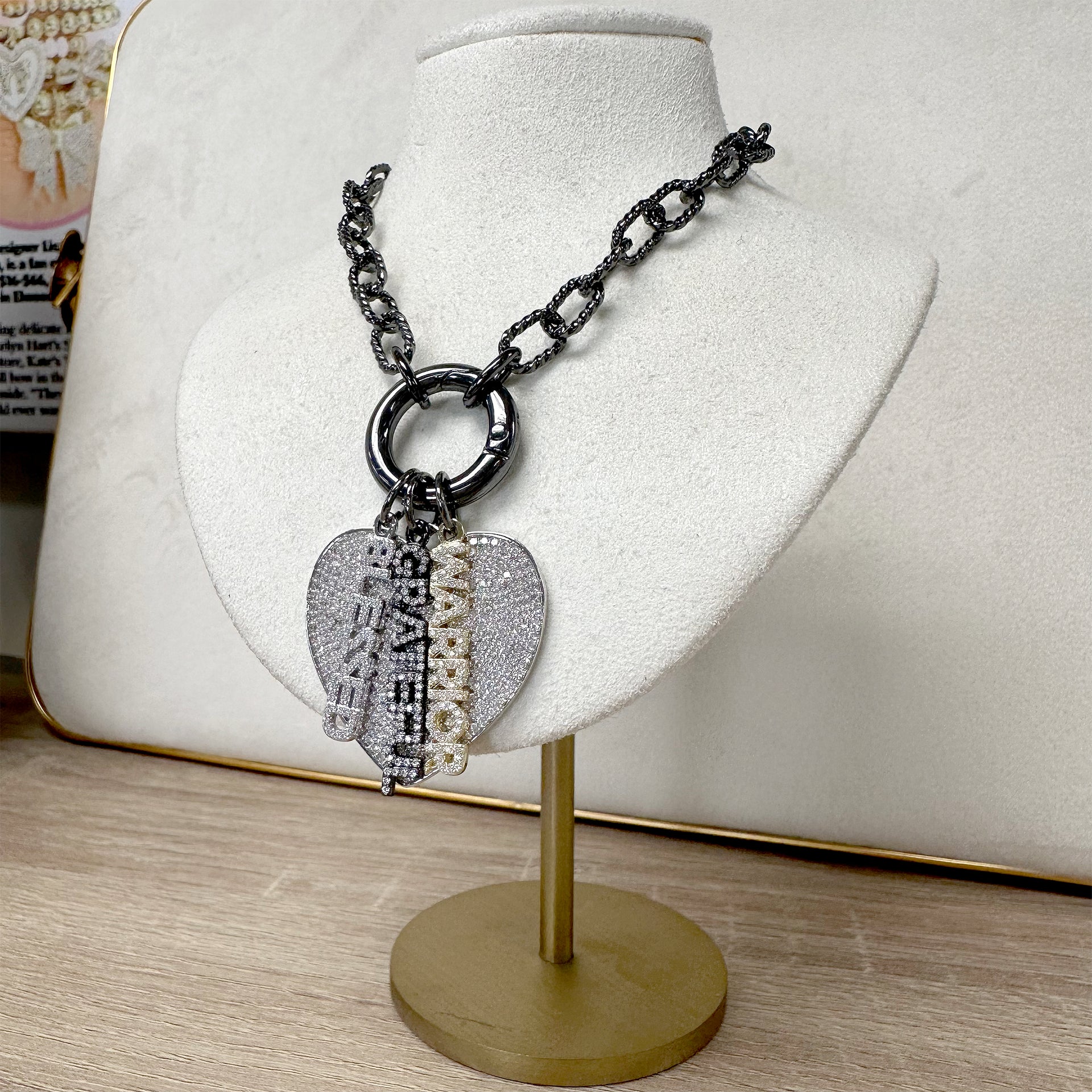 Love Lisa shimmering word charms layered with pave heart charm on clasp necklace on display
