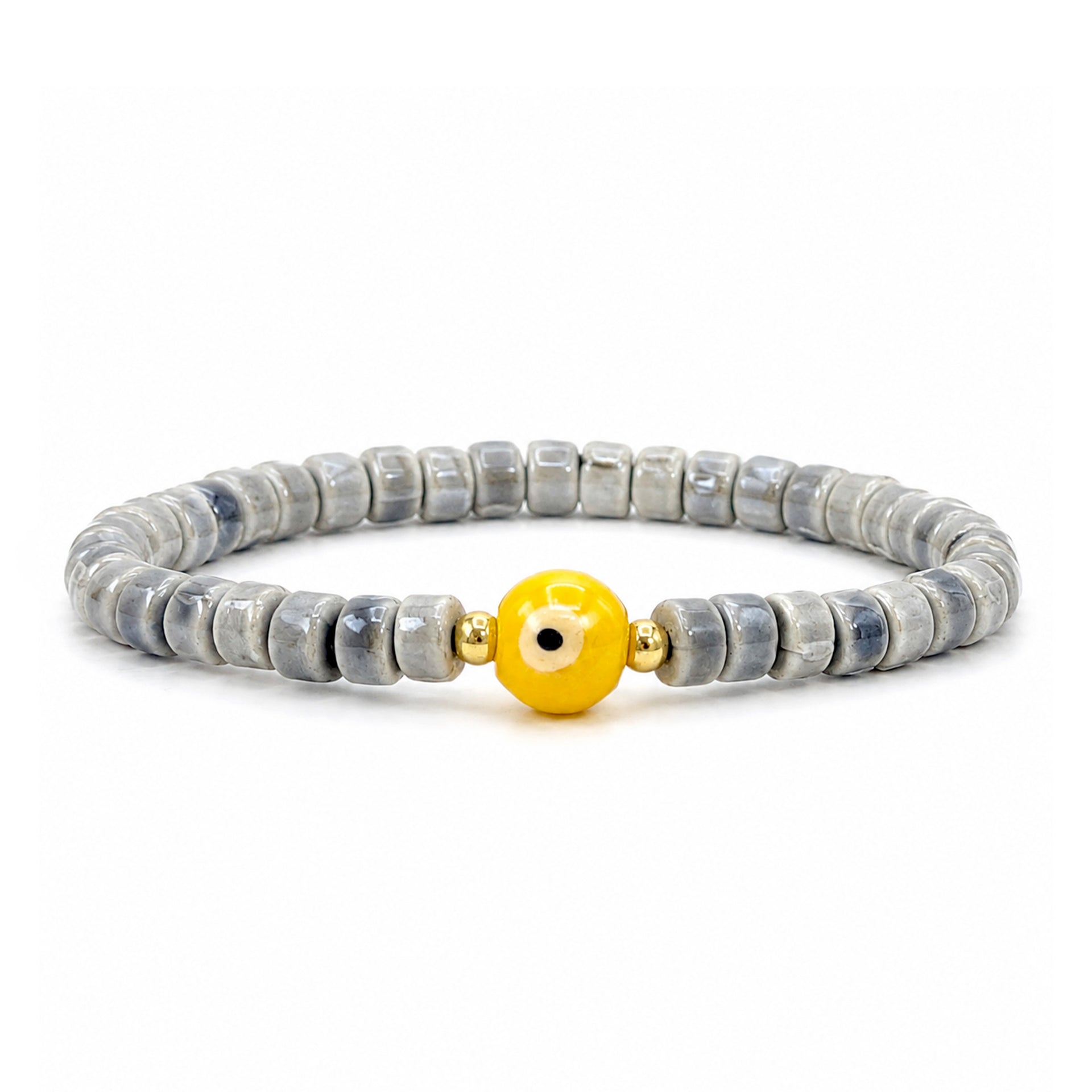 A beaded stretch bracelet featuring gray and white marbled stone beads with a central yellow evil eye charm, flanked by small gold spacer beads, on a white background.