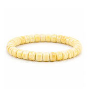 A beaded stretch bracelet made of small, rounded, light yellow beads with a glossy finish, displayed on a clean white background.