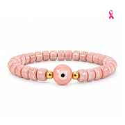 Pink ceramic evil eye bracelet with glossy pink rondelle beads and gold accents on white background