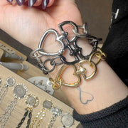 Love Lisa heart clasp chain bracelet styled on wrist layered with statement jewelry