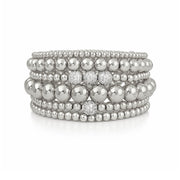 Stack of silver beaded bracelets on a white background