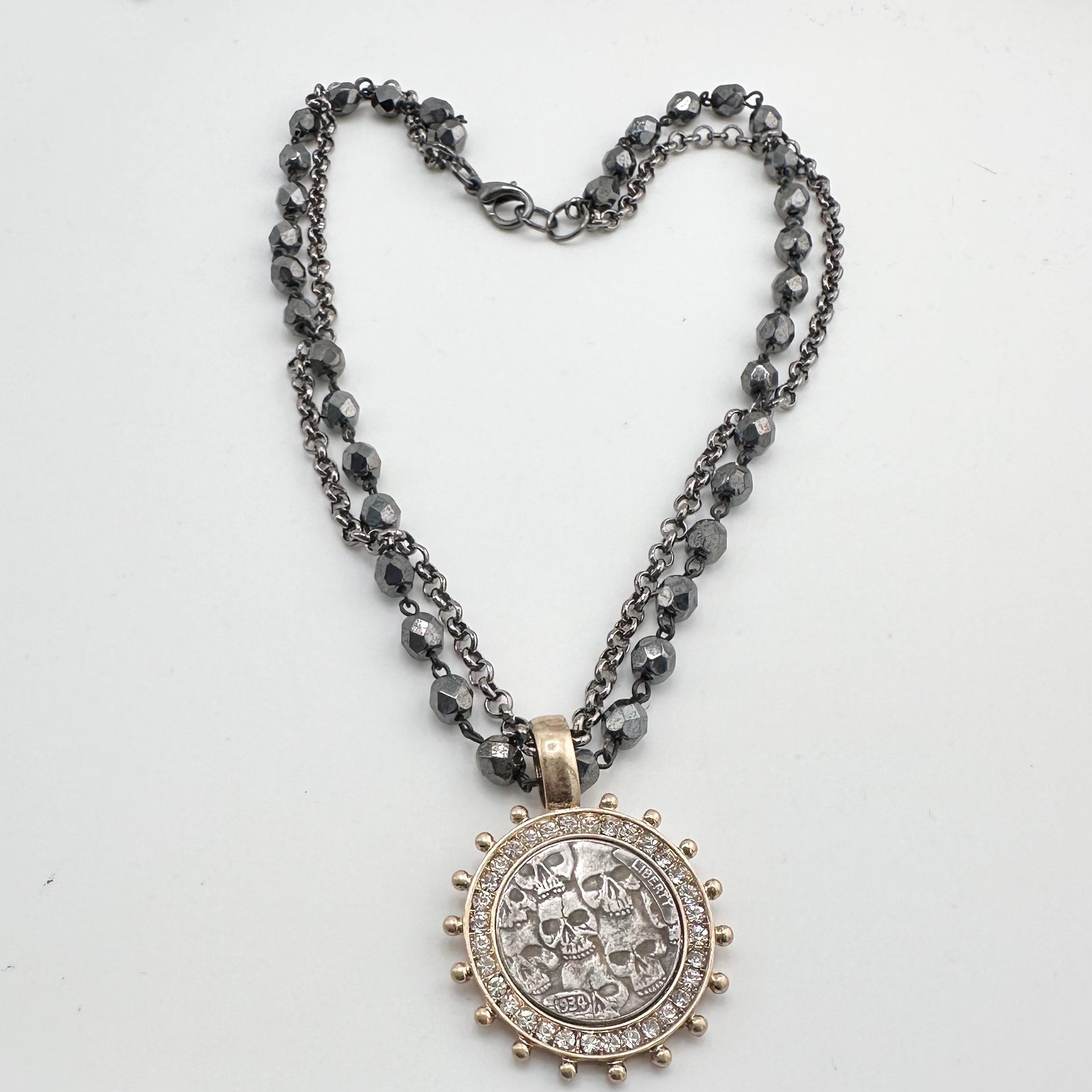 gunmetal gold skull coin necklace styled in heart shape with double chain
