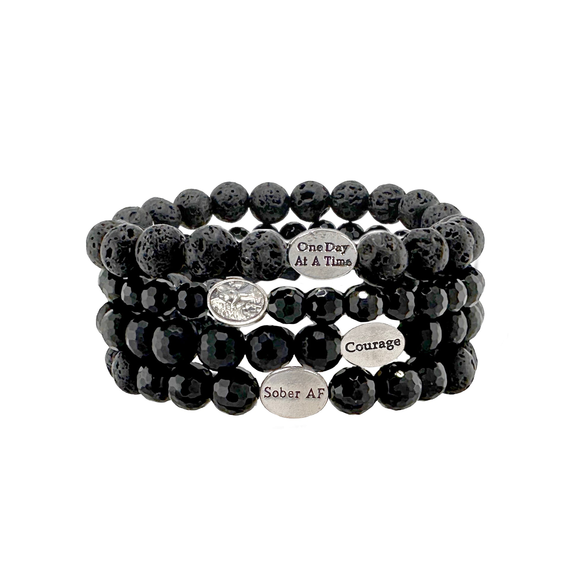 A stack of black bead bracelets with 'SOBER AF' inscribed on one, along with a silver-tone angel charm.