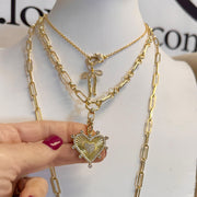 Sophia Heart Medallion Necklace styled with layered gold chains for an elegant look with bow