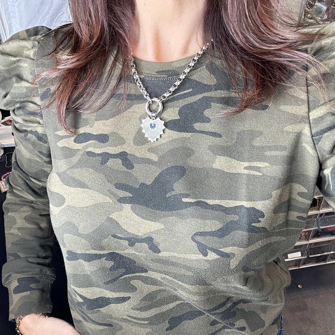 gold spiked heart necklace styled with camo shirt

