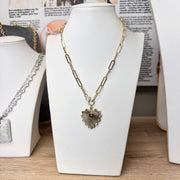 Stacy Gold Fan Heart Charm displayed on Pam Paperclip Clasp Necklace, styled on jewelry bust with magazine backdrop