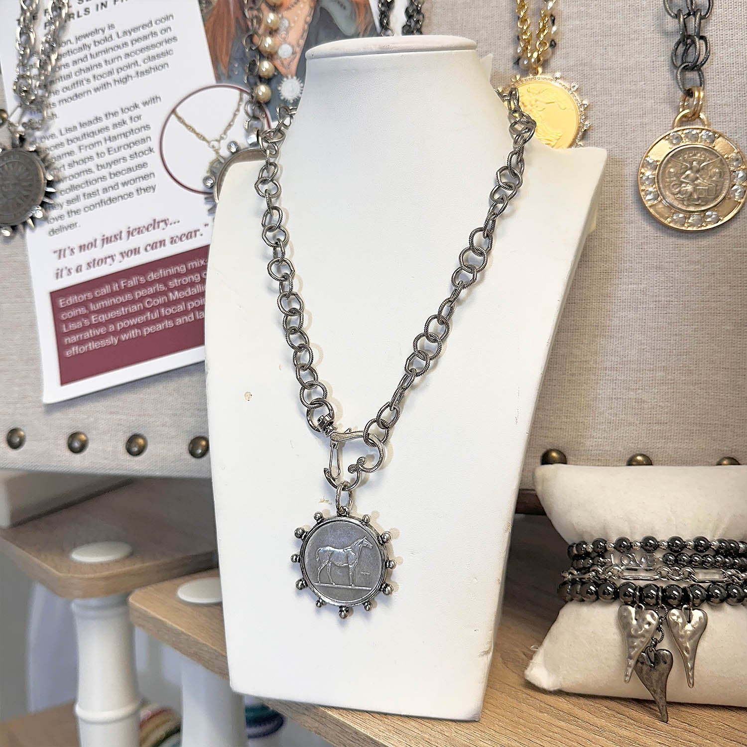 Necklace with a pendant on a white mannequin bust in a store setting.