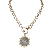 Gold necklace with a pendant featuring an engraved horse on a white background
