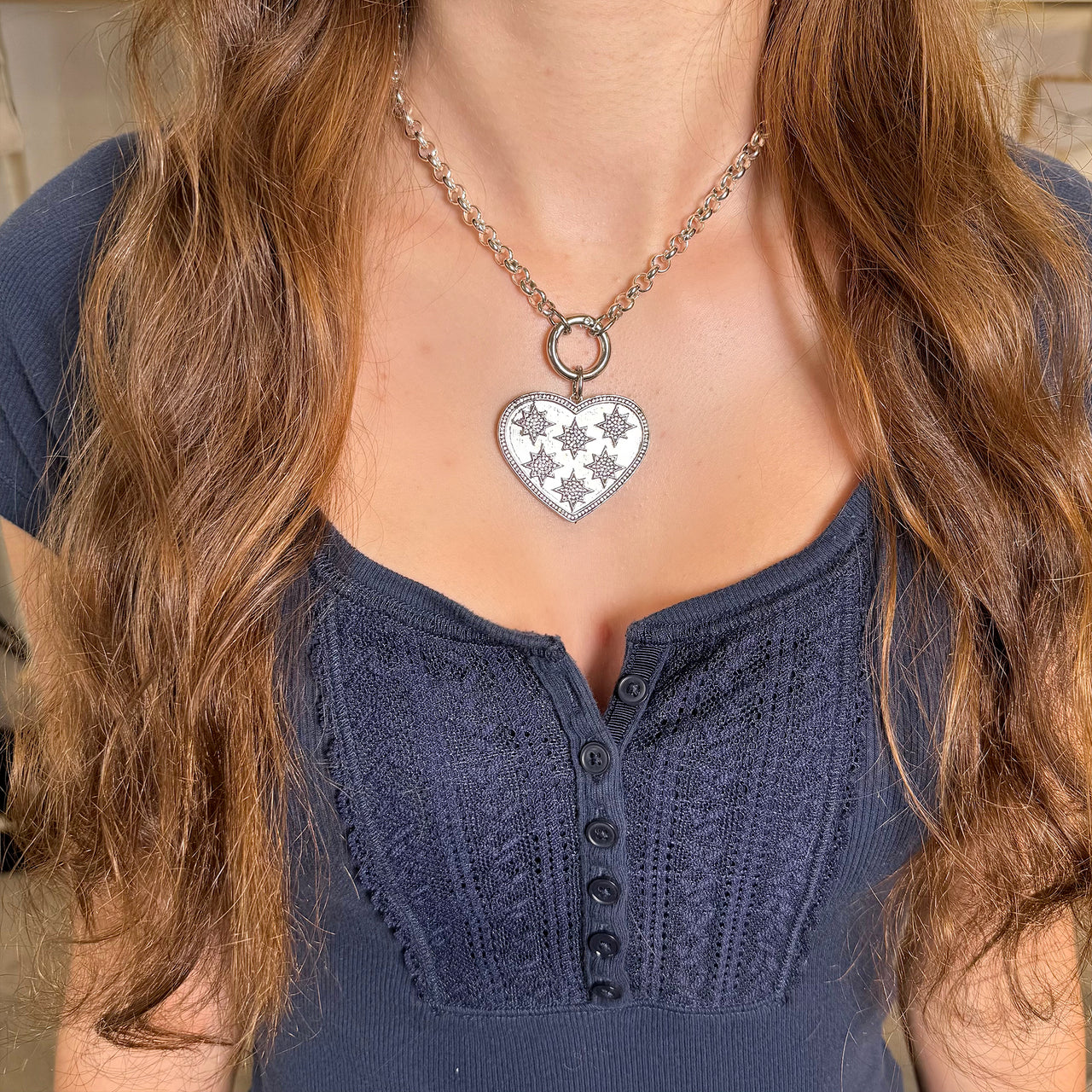 starburst heart charm worn on model layered with clasp necklace love lisa
