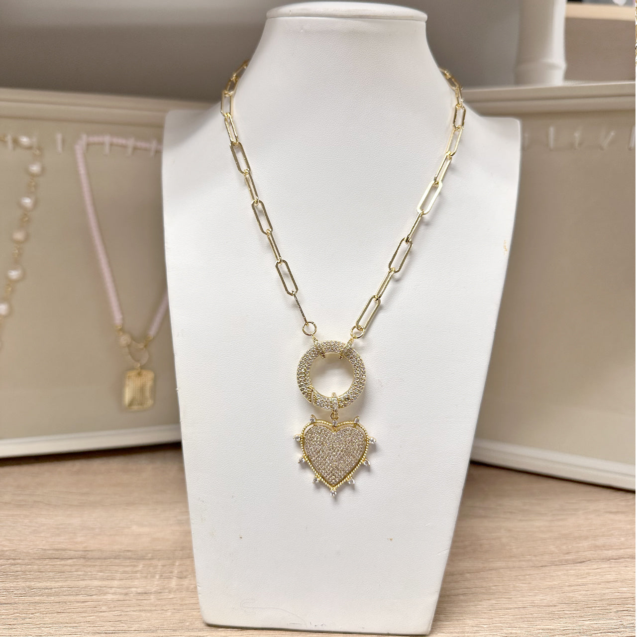 gold stellar heart necklace displayed on jewelry stand
