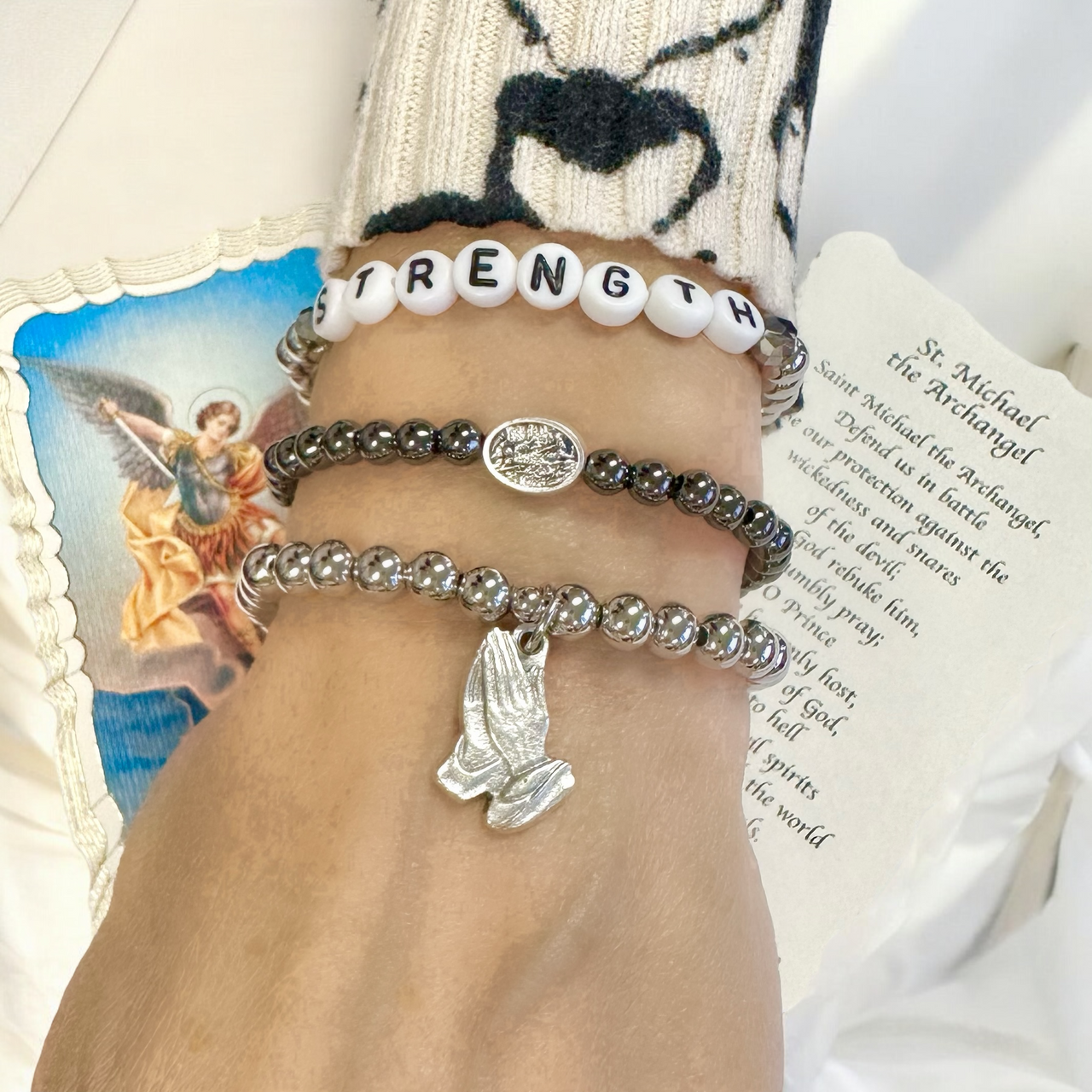 subliminal saint michael the archangel bracelet worn on model stacked with other bracelets love lisa