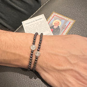 subliminal saint padre pio healing bracelet worn on male model layered with other bracelets love lisa