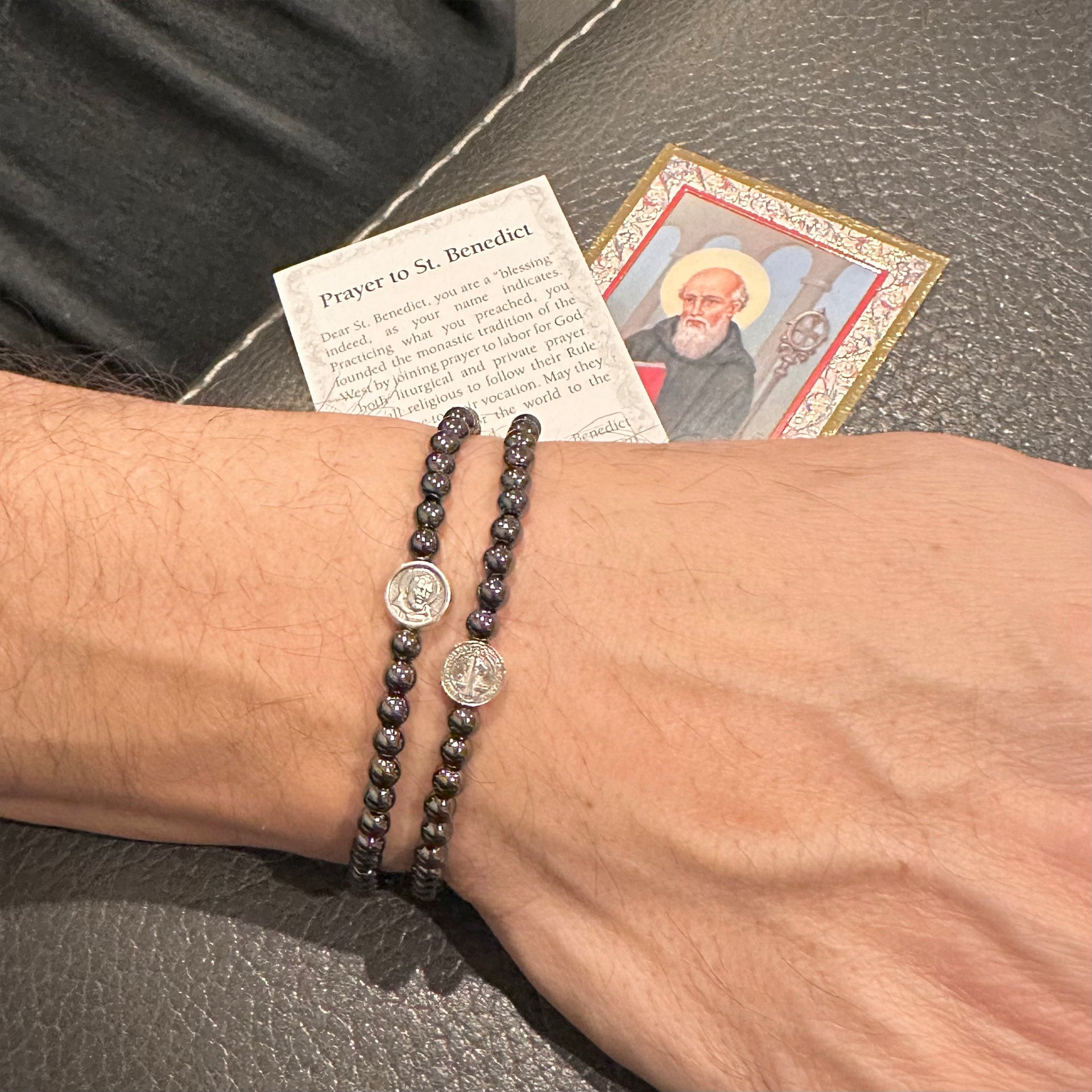 subliminal saint padre pio healing bracelet worn on male model layered with other bracelets love lisa