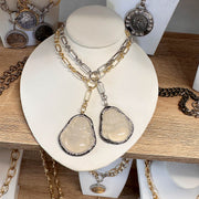 Necklace with pendant on a white stand on a wooden surface