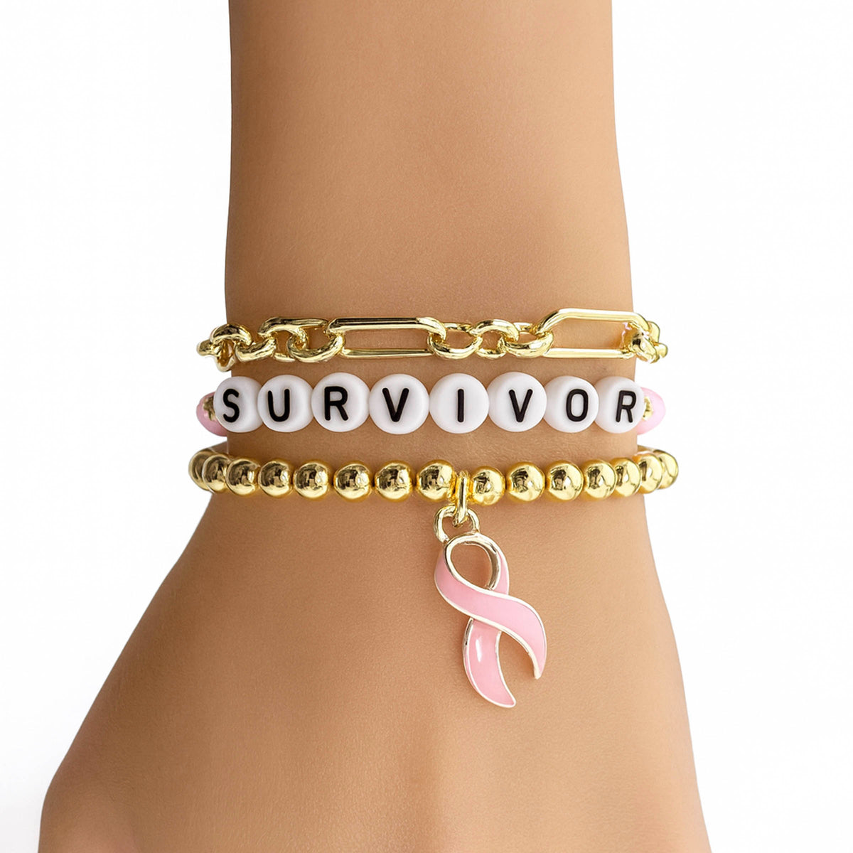 Love Lisa Survivor Breast Cancer Awareness Bracelet Stack worn on wrist in gold with SURVIVOR bead detail and dangling pink ribbon charm