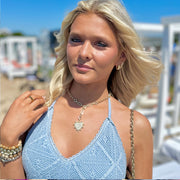 layla gold heart necklace on a model at the beach