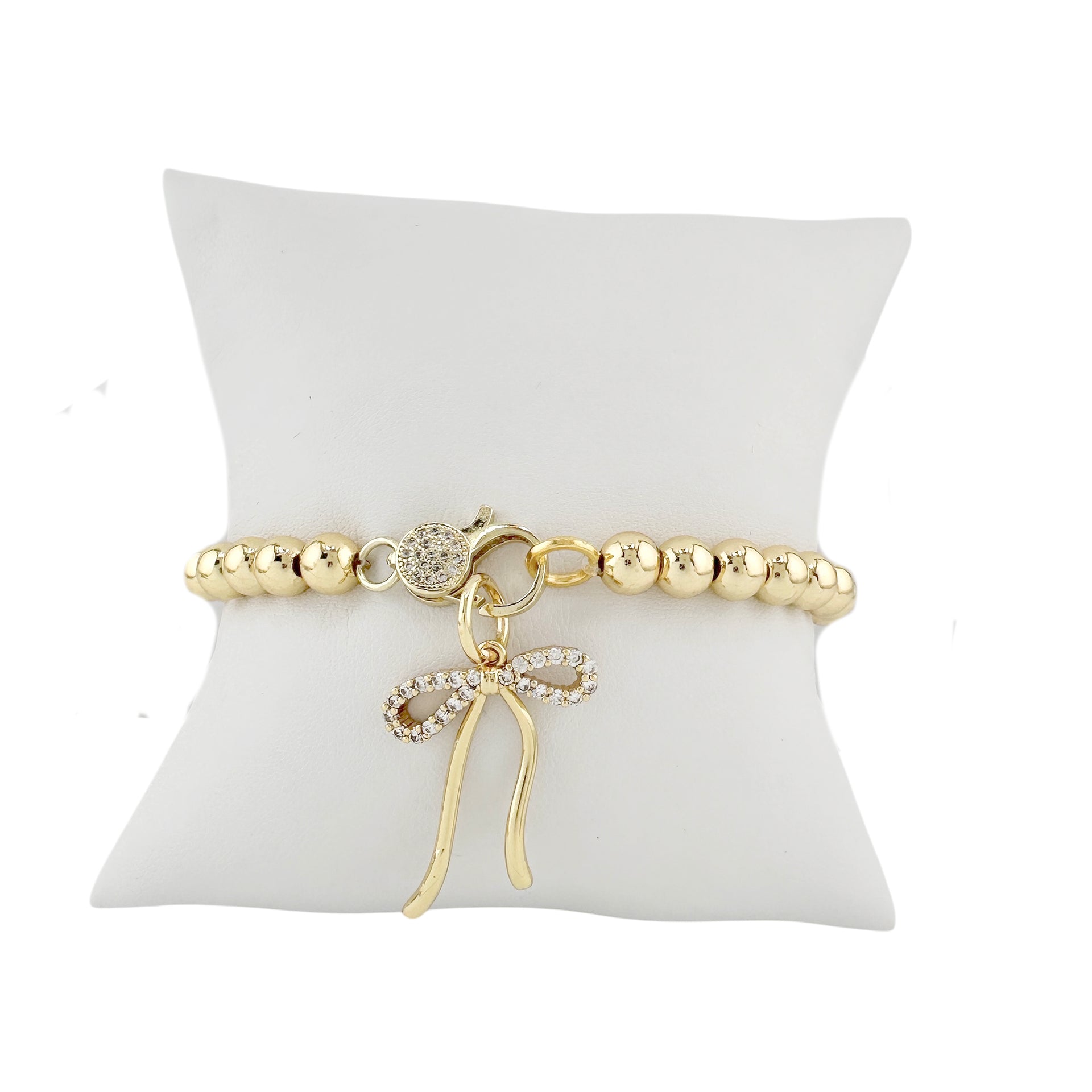Mixed metal beaded bracelet with pavé crystal clasp designed for charm customization shown with bow charm on display pillow