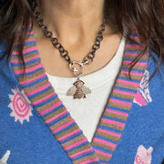 The  model is wearing a Rose Gold Queen Bee Charm is pure glam. Soft rose sparkle meets rich golden undertones for a warm, radiant finish. Feminine, fierce, and full of boss energy.