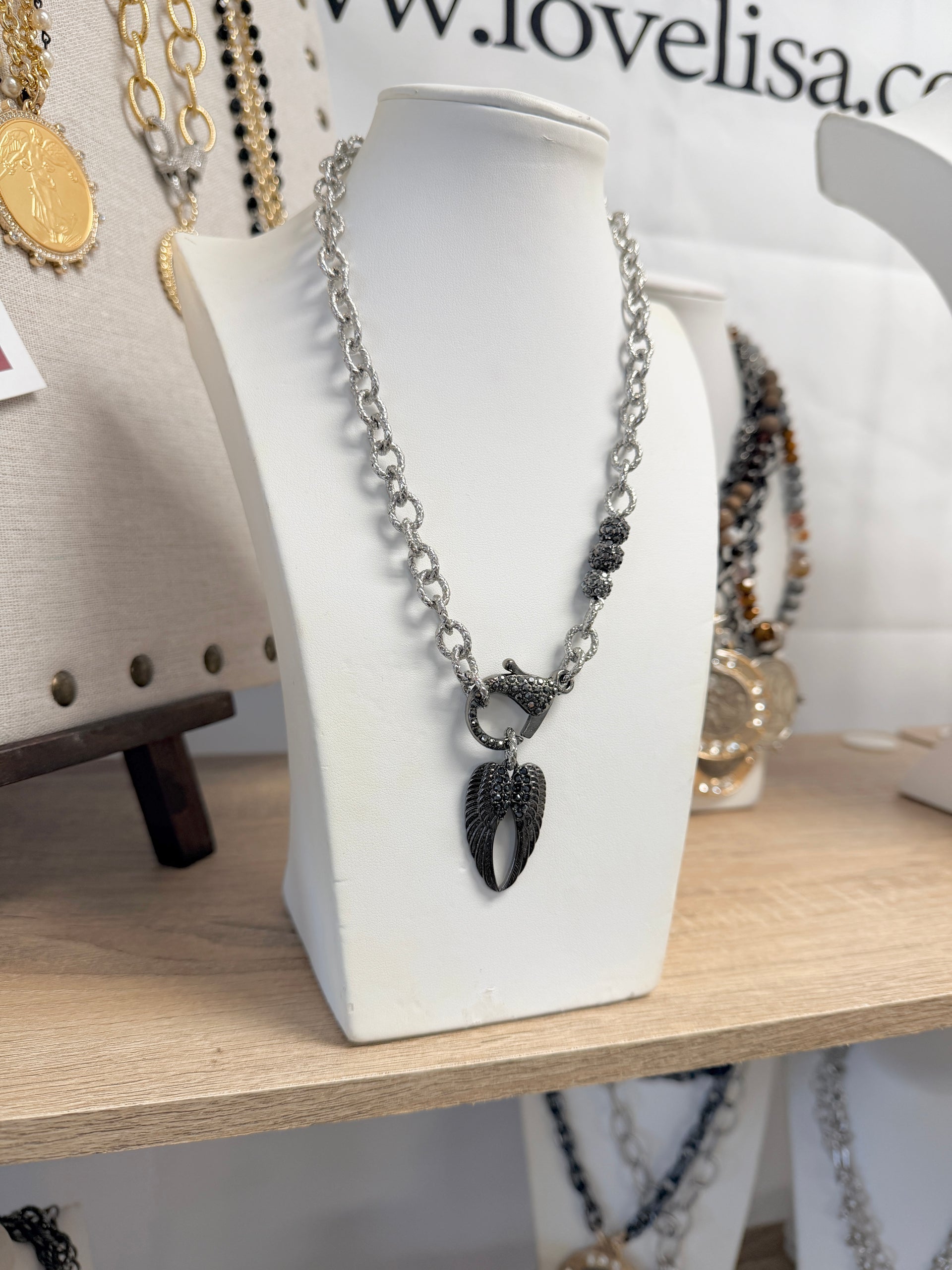 tina angel wing necklace on display stand gold silver and gunmetal wing pendant necklaces