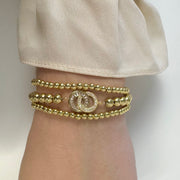 Love Lisa Together Forever gold bracelet stack worn on wrist showing layered beaded bracelets with crystal centerpiece