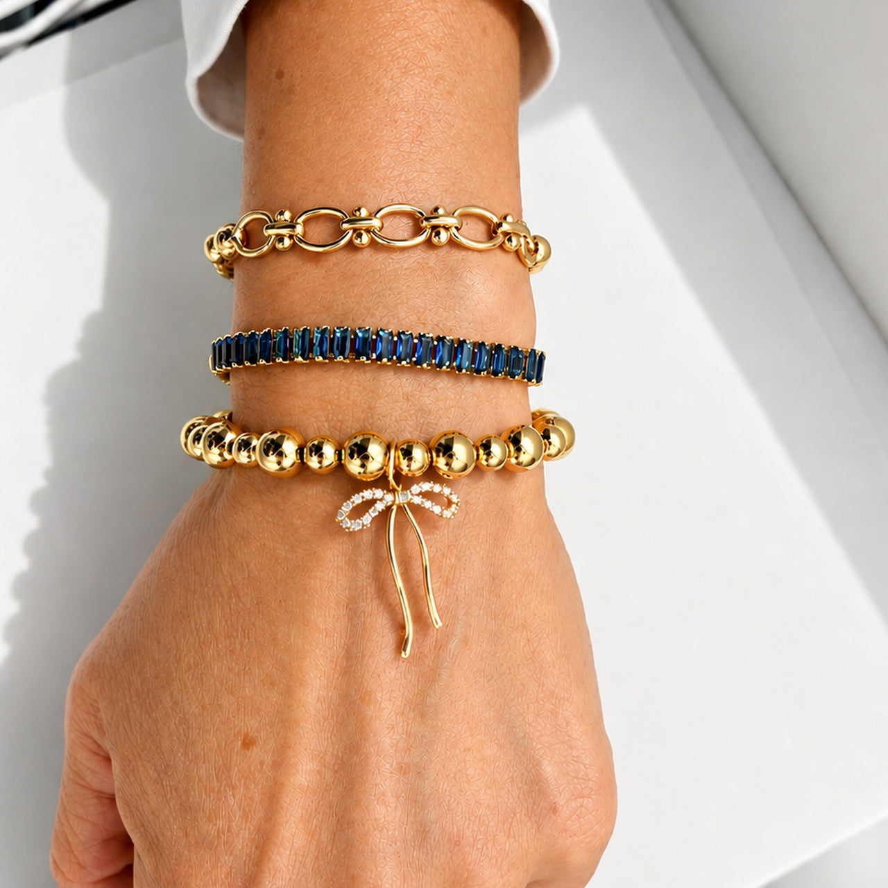 Love Lisa Trae Baguette Crystal Link Bracelet worn on wrist in a layered bracelet stack with colorful crystal and bead bracelets
