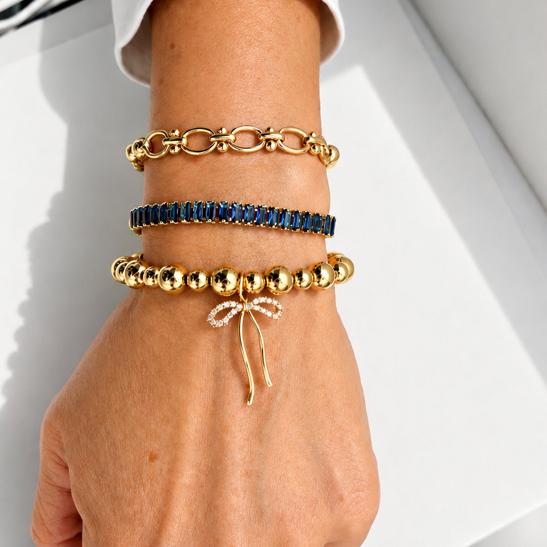 Love Lisa Trae Baguette Crystal Link Bracelet worn on wrist in a layered bracelet stack with colorful crystal and bead bracelets