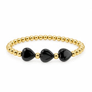 riple Mini Heart Worry Stone Bracelet with three glossy black heart-shaped stones and polished gold-tone round beads