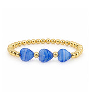 Triple Mini Heart Worry Stone Bracelet with three vivid blue heart-shaped stones centered between polished gold-tone beads