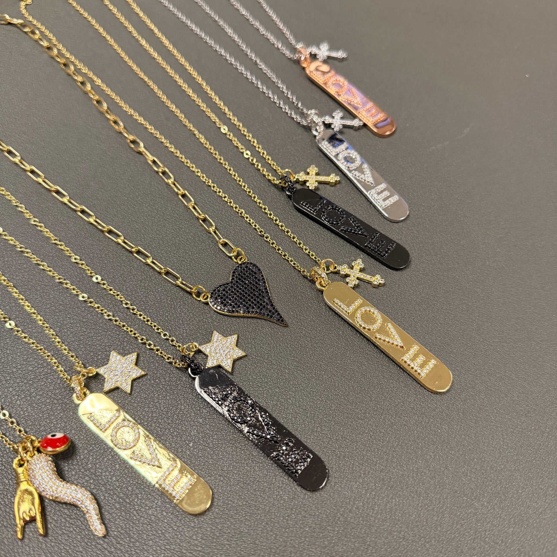 Trisha cross love tag necklace detail showcasing crystal LOVE pendant and pavé cross charm