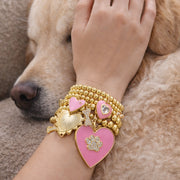 Pink heart and paw charm bracelet stack worn by dog lover gold beaded jewelry