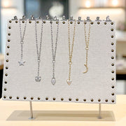 Jewelry display stand with necklaces on a blurred background